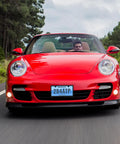 Red sports car with "Stainless Steel License Plate Frame With Slim Two Hole Design Flat Plate Holder That Keeps It Clean And Rust Free Weatherproof Car Accessory With Metal Screw Caps Black Finish Narrow Frame For Standard Plates" visible on front license plate.