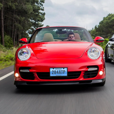 Red sports car with "Stainless Steel License Plate Frame With Slim Two Hole Design Flat Plate Holder That Keeps It Clean And Rust Free Weatherproof Car Accessory With Metal Screw Caps Black Finish Narrow Frame For Standard Plates" visible on front license plate.