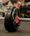 Barbell with weights and a red Anti Skid Barbell Self Locking Nuts Four Pack Red Plastic Security Nuts for secure lifting.