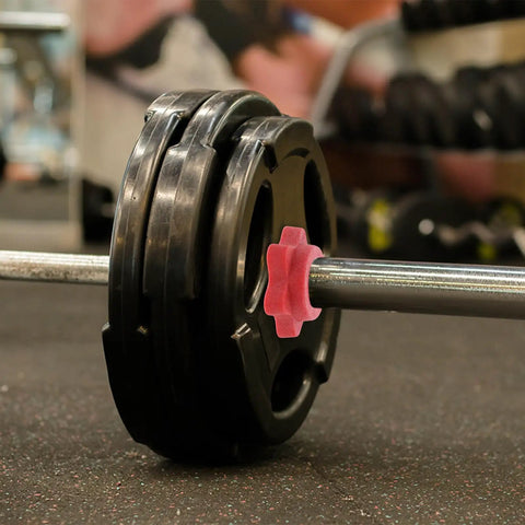 Barbell with weights and a red Anti Skid Barbell Self Locking Nuts Four Pack Red Plastic Security Nuts for secure lifting.