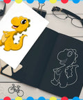 Sketchbook with dinosaur drawing and colored print, glasses and decorative items on a wooden surface with bordered design.