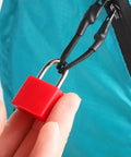 Red lock from 10 Pack Small Luggage Locks With Keys, No Fuss Durable Metal Padlocks For Suitcases, attached to a blue zipper