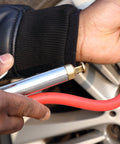 Close-up of hands using the Bayonet Style Tire Inflator Gauge with 12 inch heavy duty air hose and straight head chuck on a car tire