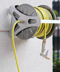 Heavy Duty Stainless Steel Garden Hose Reel With Smooth Rollup Crank mounted on wall storing a yellow hose neatly.