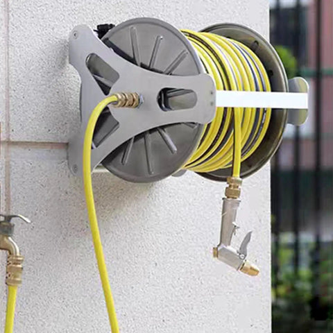 Heavy Duty Stainless Steel Garden Hose Reel With Smooth Rollup Crank mounted on wall storing a yellow hose neatly.