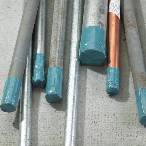 Metal pipes wrapped in Heavy Duty Duct Tape Outdoor Grade Slate Blue 48 Mm By 55 M Roll Pack, used for protection on construction site.