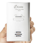 Hand holding Plug In Carbon Monoxide Detector With Battery Backup, 85 DB Alarm, LED Status Lights, Peak Memory, Easy Setup