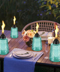Four Pack Refillable Table Top Citronella Torches With Glass Canisters 12 Oz Each Blue Outdoor Lighting on dining table