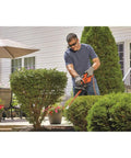 Man using a 16 Inch Hedge Trimmer With Dual Action Blade And Saw Blade 3.0 Amp Motor Delivers Less Vibration Cuts Branches Up To Five Eighths Inch