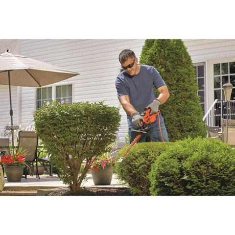 Man using a 16 Inch Hedge Trimmer With Dual Action Blade And Saw Blade 3.0 Amp Motor Delivers Less Vibration Cuts Branches Up To Five Eighths Inch