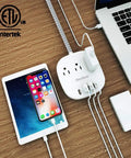 Desktop Power Strip With Three Outlets And Four USB Ports No Brainer Charging For All Your Gadgets Fast 4.5 Amp USB Quick Charge Flat Plug 5 Ft Braided Extension Cord Great For Cruise Ship Travel And Home Office ETL Listed in use with devices connected on wooden desk.