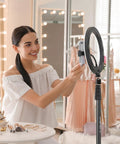Woman using Extendable 6.23ft Aluminum Light Stand For Photography with smartphone in dressing room setting.