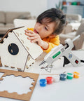 Child using Dope Mini Hot Glue Gun Kit With 30 Glue Sticks, Fast Heating Hot Melt Gun For School Projects, Crafts, DIY Arts And Quick Home Repairs, High Temp, Compact White Tool For Everyday Fixes to assemble a wooden birdhouse.
