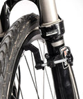Ultra Portable Bike Wheel Truing Stand For On The Go Rim Adjustment, MTB And Road Bike Wheel Repair Tools attached to fork.