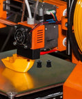Get Your 3D Printer Running Smooth With This Awesome 5Pc Gt2 Timing Belt Pulley Kit Made From Durable Aluminum Alloy Perfect For DIY Builders And Crafters Who Need Reliable Parts For Their Next Big Printing Project. Black GT2 pulley on orange 3D printer extruder
