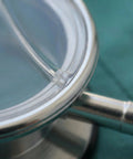 Stethoscope diaphragm replacement close-up; metal rim and clear membrane.