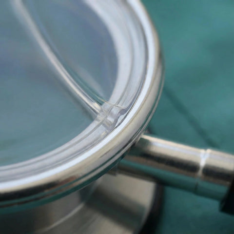 Stethoscope diaphragm replacement close-up; metal rim and clear membrane.