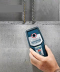 Heavy Duty Stud Finder Wall Scanner With Snappy Metal And AC Wire Detection Drywall Pipe Locator Digital Scanner held against concrete wall.