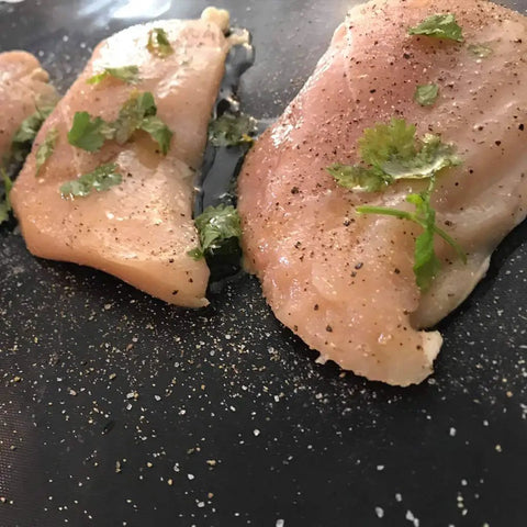 Raw chicken seasoned with herbs on Heavy Duty Grill Mats Set Of 5 Nonstick BBQ Mats For Outdoor Grilling And Indoor Baking Reusable