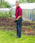 Man installing Tall Dog Fence With Gate, 40 Inch High Garden Boundary Fences, 12 Panels Spanning 26.2 Feet, Metal Temporary Yard Enclosure For Pets.