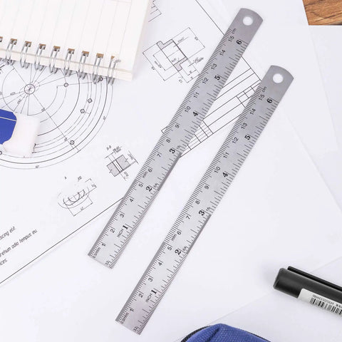 6 Inch Stainless Steel Ruler Set Of 4 With Safe Non Sharp Edge For Students And DIY Projects Durable Rustproof Metal Measuring Tool For Precise Lines And Crafting placed on technical drawings.