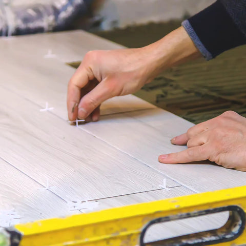 White 1/16-inch cross tile spacers, 500-pack, shown on ceramic tiles during installation