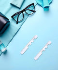 Two Piece White Pupil Distance Ruler For Eye Care And Prescription Eyeglasses PD Meter With Monocular And Binocular Measurement Options And Easy Read Scale, two white rulers on blue background