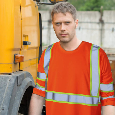 Man wearing Six Pack Safety Long Sleeve T Shirt With 360 Degree Reflective Strips Class 3 High Visibility Orange near a construction truck.