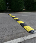 Eco XPT Speed Bump Kit With Cable Channel for Private Roads on Asphalt, showing black and yellow reflective modular design with mounting hardware.