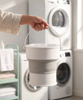 Sweet Compact Folding Mini Washing Machine Portable Travel Washer For Socks Underwear And Delicates Quick Rinse Auto Drain Straight Up Compact Design For Dorms held by a person, featuring a collapsible bucket.