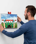 User leveling a picture frame with Sola Spirit Level Compact Go! Clip, 0 mounted on top for accurate alignment.