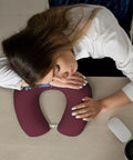 Woman resting on Custom U Shaped Neck Pillow With Your Design, Personalized Memory Foam Travel Pillow For Plane, Car, Home Or Office, Add Photos Or Text, Maroon Color, Soft Support For Naps And Fatigue Free Travel on desk.