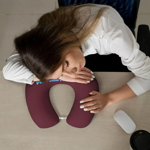 Woman resting on Custom U Shaped Neck Pillow With Your Design, Personalized Memory Foam Travel Pillow For Plane, Car, Home Or Office, Add Photos Or Text, Maroon Color, Soft Support For Naps And Fatigue Free Travel on desk.
