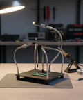 Helping Hands Soldering Station With Magnifying Glass 2.5X, 4 Flexible Arms PCB Holder on a workbench with tools in background