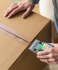 Hands using EZ Start Packing Tape With One Handed Dispenser 1.88 Inch By 55.5 Yard Crystal Clear Tape Roll sealing a box