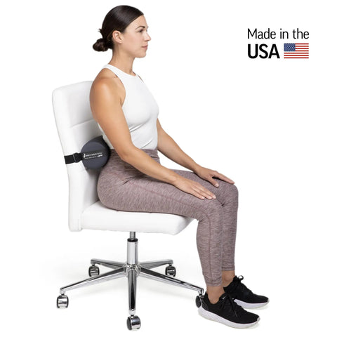 The Original McKenzie Lumbar Roll Standard Density Low Back Support Pillow for Comfort spinal alignment used on office chair by woman.