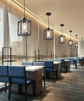Rock Solid Black Pendant Lights For Kitchen Island, 3 Pack Sleek Industrial Farmhouse Lanterns with adjustable height above blue seating area.