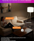 Woman using Alexa Ready Smart Bulb 10W 900 Lumens 2700K Warm White 2 Pack with smart speaker connection in living room.