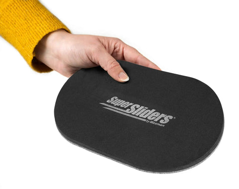 Person holding an XL oval felt furniture slider for hard surfaces, reusable anti-slip moving pad, set of 4, protects hardwood floors.