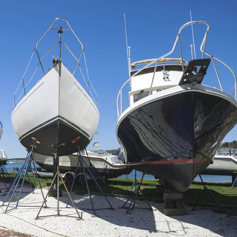 Two boats on stands by the shore, ideal for Marine Grade Lubricant and Penetrating Oil for Boats and Gear NSF H1 Marine Formula use.