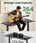 Rock This Dual Motor Standing Desk Frame For 44 To 90 Inch Desktops, supports 264 lbs, displayed with a person playing guitar.