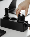 Hand placing distributor in Walnut 4 In 1 Espresso Knock Box And Tamping Station With Portafilter Holder Tamper Holder And Distributor Holder For 51 To 54 Mm Espresso Gear Keeps Your Coffee Station Neat And Dope For Home Baristas And Small Cafes