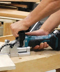 Man using 18V LXT Cordless Plate Joiner with Rack and Pinion Fence Aluminum Pivot Fence for precise woodworking biscuit joints