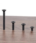 Five Piece Set Black Stainless Steel Phillips Head Self Tapping Wood Screws 4x40mm displayed on wooden surface