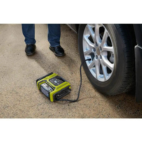 Cordless 18V Dual Function Inflator Deflator Tool for inflating car tire, shown on the ground next to vehicle on driveway