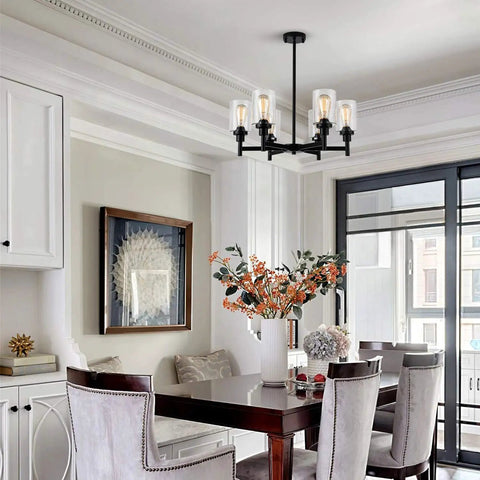 Black Farmhouse Chandelier With Six Clear Glass Shades Hanging Over Dining Table Featuring Sturdy Metal Frame And Sleek Modern Design That Hits Different For A Killer Centerpiece Vibe In Any Home Space in a stylish indoor dining area.