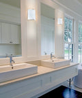 Slick Modern 1 Light Vanity Wall Sconce with Dimmable LED, milky glass front, silver accents, in a bathroom setting.