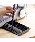 Dead Simple Desktop Comb Binding Machine That Crushes 25 Sheets Fast, inserting purple comb binding into unit.