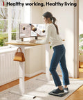 Person using Electric Height Adjustable Standing Desk 40x24 Inches with white frame and maple top in home office