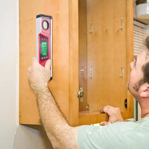 Person using 10 Inch Digital Level and Protractor with IP54 Inclinometer, Large LED Backlight Display on wooden cabinet